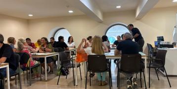 Groups of people sitting at tables discussing project