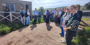 Stakeholders gathered at Finca La Jerrizuela (Coo–Los Corrales), standing attentively while listening to the researchers’ presentation.