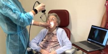 A nurse takes a video of the older person's oral cavity