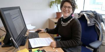 Interreg Youth Volunteer Pauline sitting at her desk with a computer