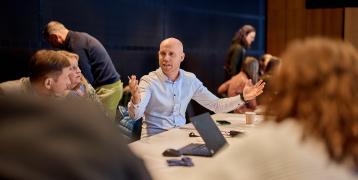 Zoom on man speaking around a table 