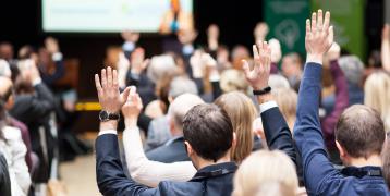 Participants of an event raising hands Participants of an event raising hands during a plenary