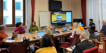 People attending a meeting with screen