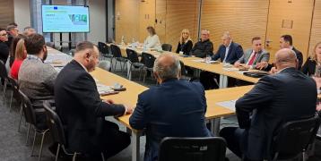 Photo of the meeting room with participants listening to presentations