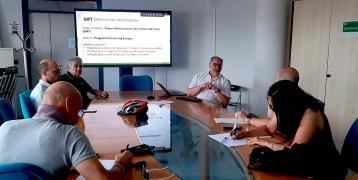 Stakeholders at the third GIFT Regional Stakeholder Group meeting in Rimini, July 2024, discussing upcoming study visits. A presentation on the GIFT project is displayed on a screen, with participants seated around a conference table, taking notes and engaging in discussion.