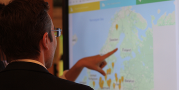 People looking at map on screen People looking at map on screen