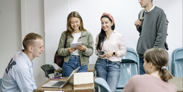 People sitting and standing around table People sitting and standing around table