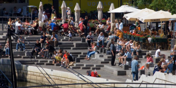 People sitting on steps near water