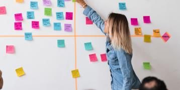 Person sticking post it to the wall Person sticking post it to the wall