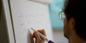 Person writing on white board