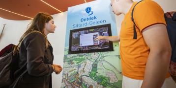 Two persons using the Inspiration Screen for the municpality Sittard-Geleen