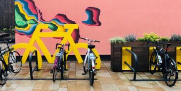 Row of bike in front of a colorful wall 