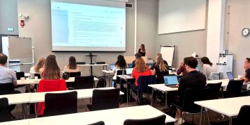 People in a meeting room, listening to a presentation about the TEXAD project