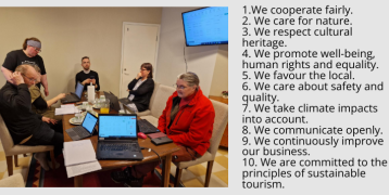 Six people working together around the table with laptops