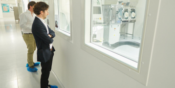 Two people looking at machines through a window