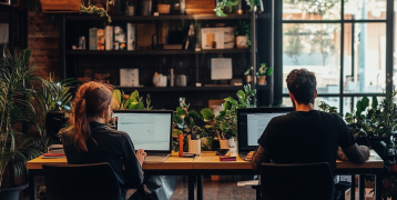 Two people working at a desk in a coworking space
