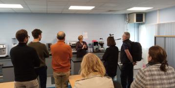people stand in a room where a guide explains the barista room in the training centre