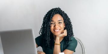 Woman smiling from behind a computer Woman smiling from behind a computer