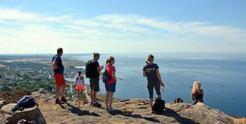Persons hiking and looking at the sea from a cliff on a dunny day