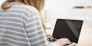 A close up women using laptop at home