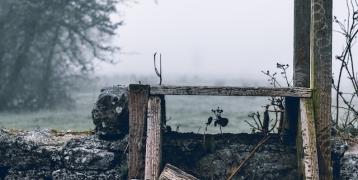 A little wooden broken staircase on a stone wall in a natural landscape