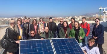 Partners gathered around a PV panel in Granada province roof