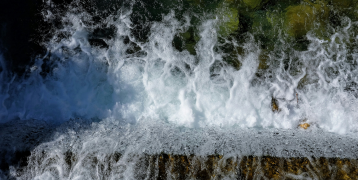 Water breaks on the edge of a cliff