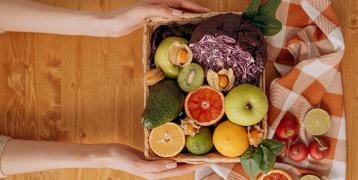 Woman holding fruit and vegetables basket
