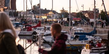 Port with numerous boats and people strolling