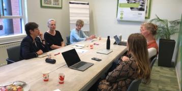 5 Women sitting in a table discussing strategies do reduce waste