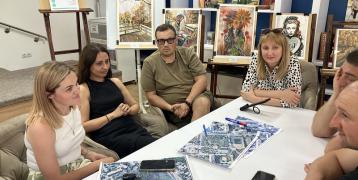 People sitting around a table with aerial photographs of the town