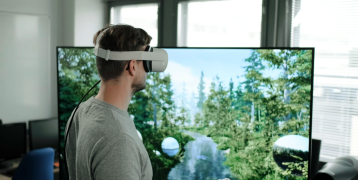 Man with virtual glasses in front of a screen with a forest landscape